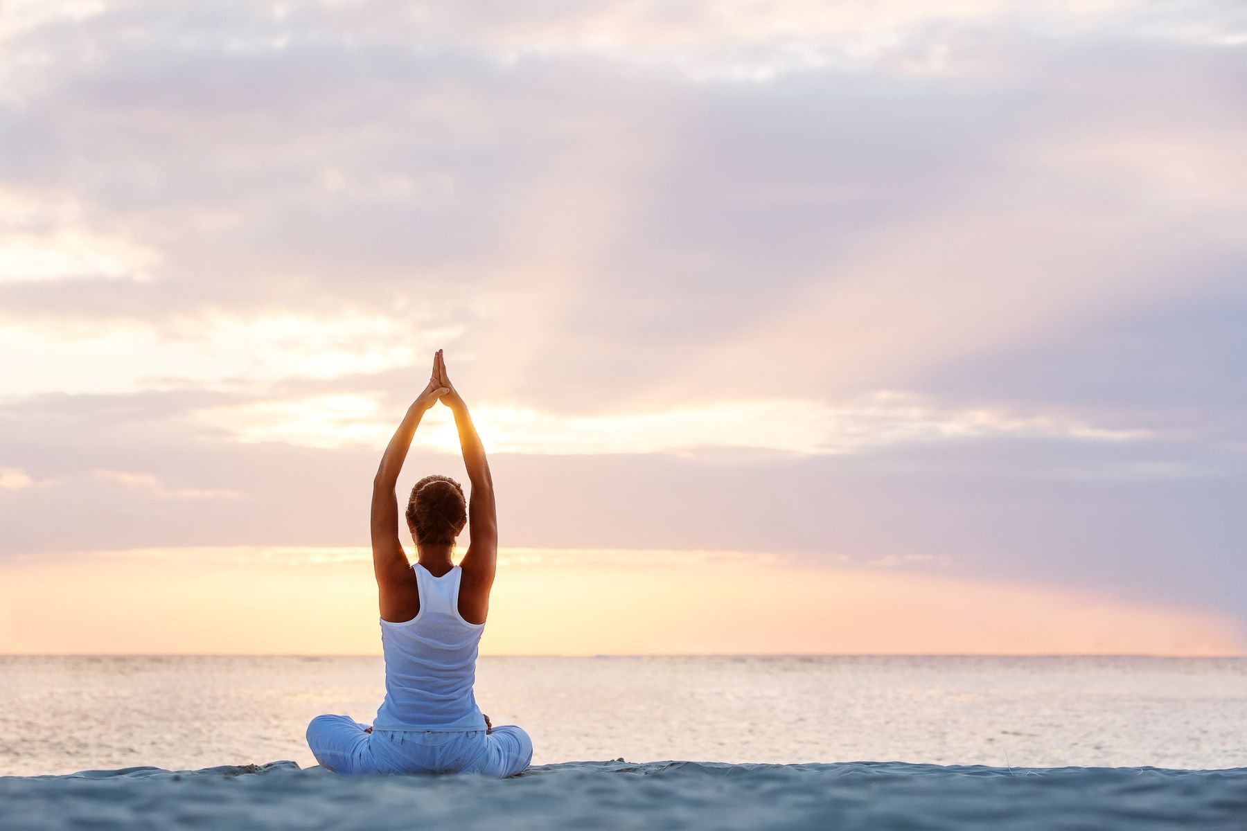 woman practicing beach yoga